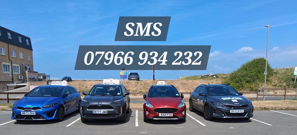 The SMS Driving School fleet of four dual control cars, manual and automatic, parked at the seafront
