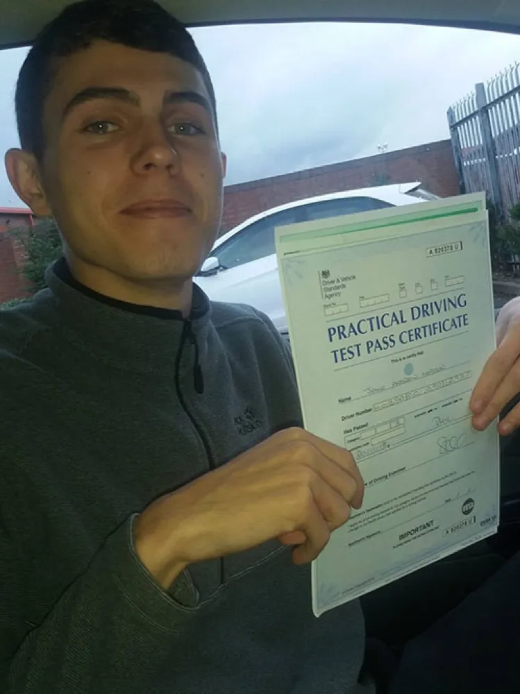 An SMS Driving School pupil holding their driving test pass certificate at Rhyl test centre