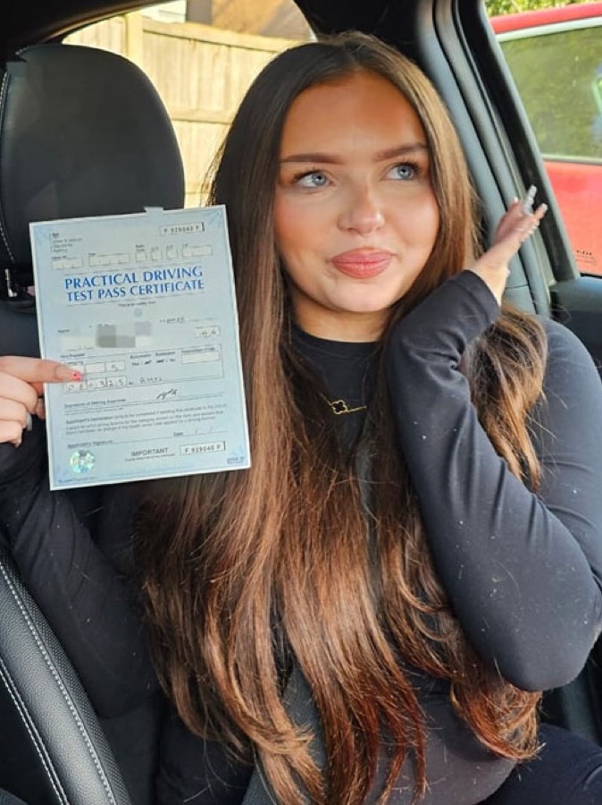 An SMS Driving School pupil celebrating passing their driving test at Rhyl test centre