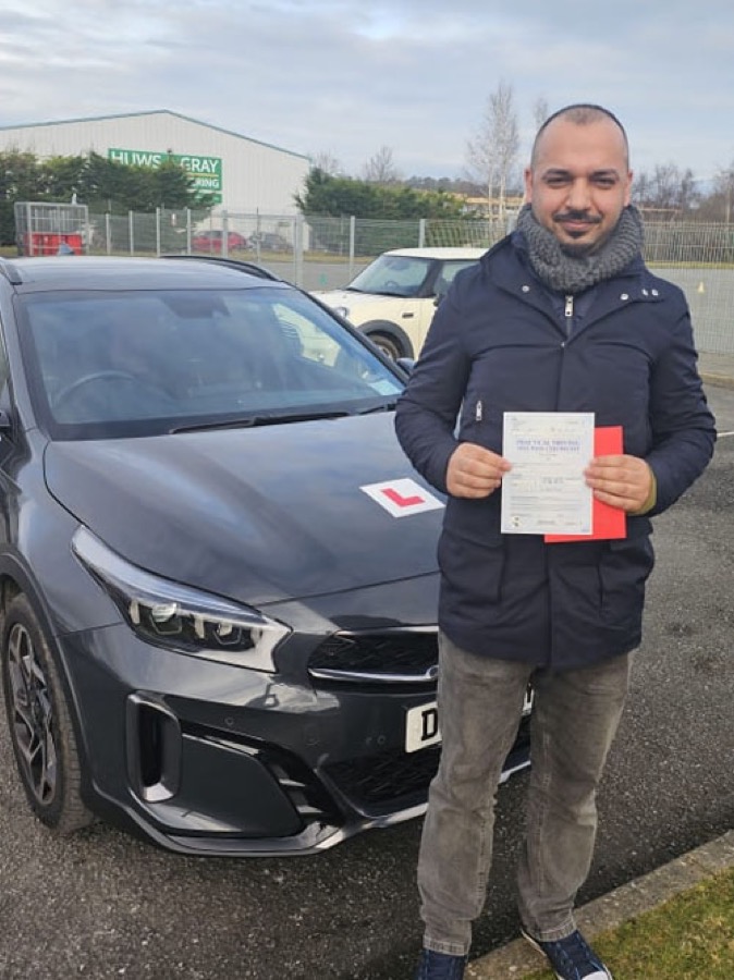 An SMS Driving School pupil celebrating passing their driving test at Rhyl test centre