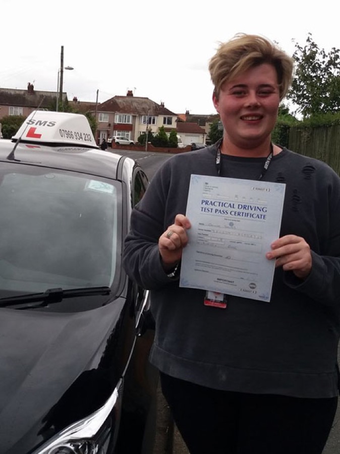 An SMS Driving School pupil celebrating passing their driving test at Rhyl test centre